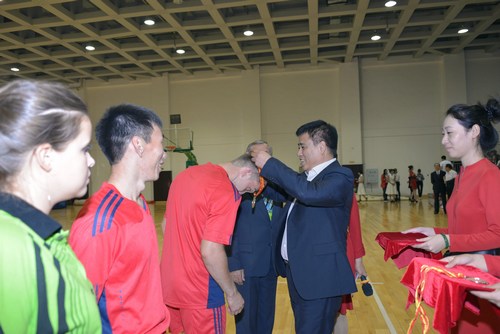 黑龙江中医药大学副校长王喜军为参加乒乓球比赛的俄罗斯大学生颁奖