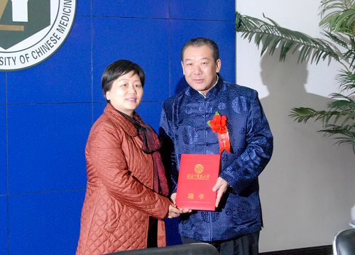 谭卫星副书记(左)代表福建中医药大学向李冀教授颁发“中医药学术思想传承指导教师”聘书