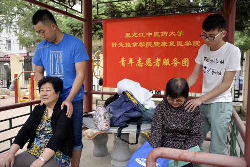 针灸推拿学院暨康复医学院的学生志愿者为老同志们按摩