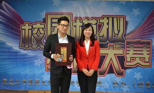 黑龙江电视台《创意者》栏目总编于淼(右)为一等奖获得者陈光滔同学颁奖