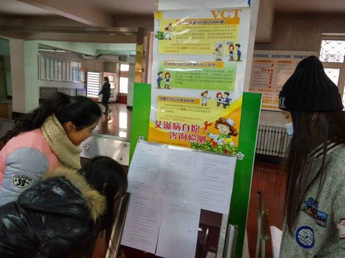 同学们驻足观看防艾宣传品
