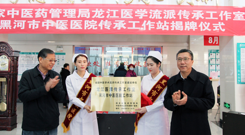 附属第一医院党委书记李建民(右)为“龙江医派传承工作室黑河市中医医院工作站”揭牌